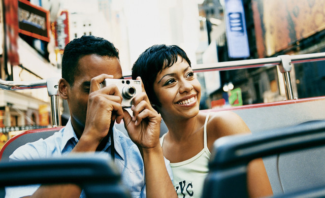 Couple Taking Pictures of NYC on Tour Bus