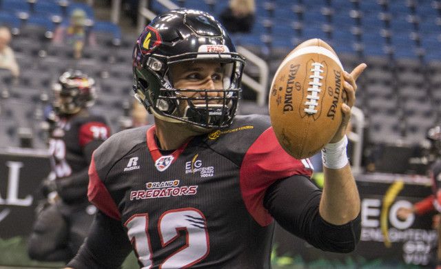 Football Player on Field Holding Ball | Sporting Event Trip Rates in Las Vegas