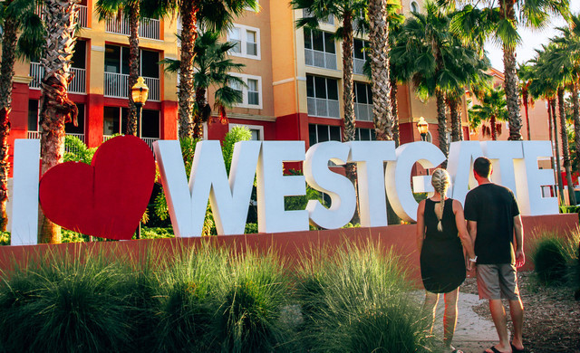 Couple Holding Hands in Front of Westgate Sign | Reviews | Westgate Town Center Resort & Spa in Orlando | Westgate Resorts