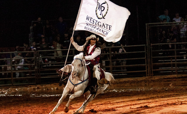 Our Florida Rodeo | Woman riding Horse Holding Westgate Flag
