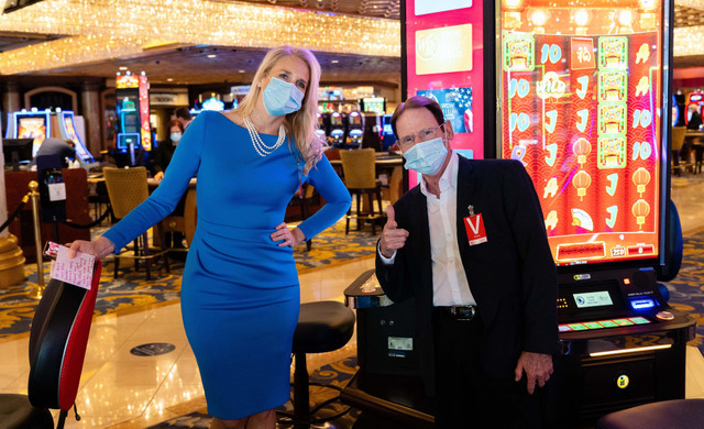 Grandes juegos de casino | Pareja sentada junto a la máquina tragamonedas