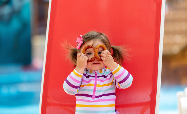 Little Girl Holding Onion Rings on Slide