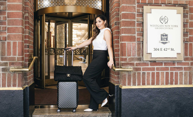 Mujer de pie en la entrada del Westgate New York Resort con equipaje