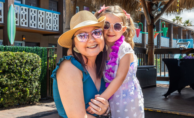 mother and daughter smiling in the sun at a beach resort play area - westgate cocoa beach