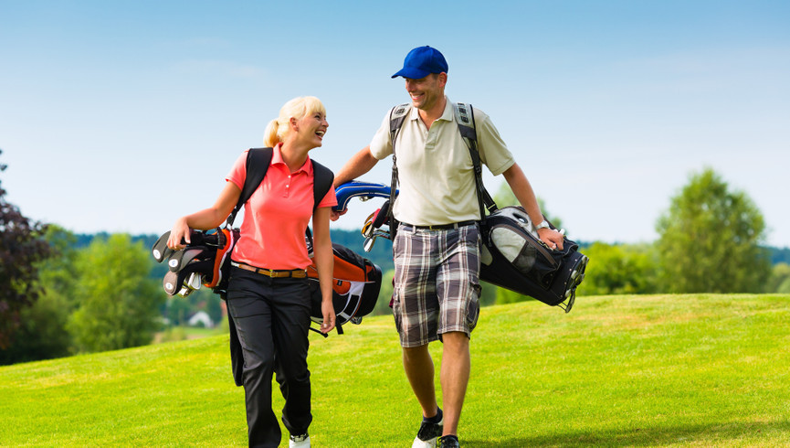 Pareja con equipo de golf en Gold Course en Westgate Painted Mountain Resort