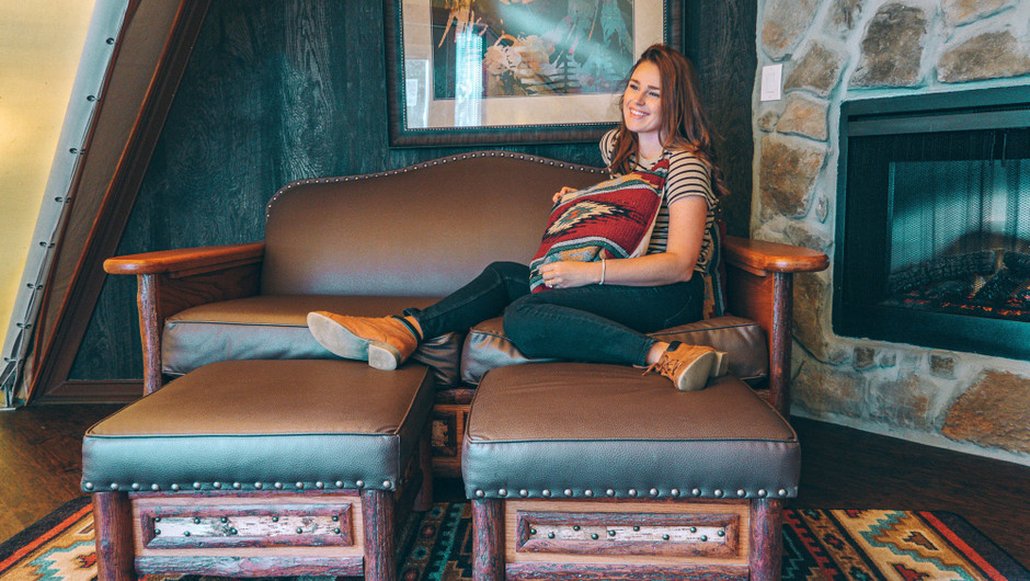 Girl sitting in the living area inside a Luxe Teepee Room - Westgate River Ranch Resort & Rodeo