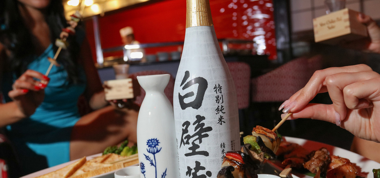 People Enjoying Bottle of Sake and Food | Westgate Las Vegas