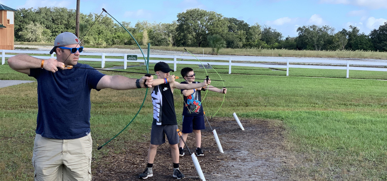 Digital Detox Retreat for Kids – Kids and Dad Practicing Archery