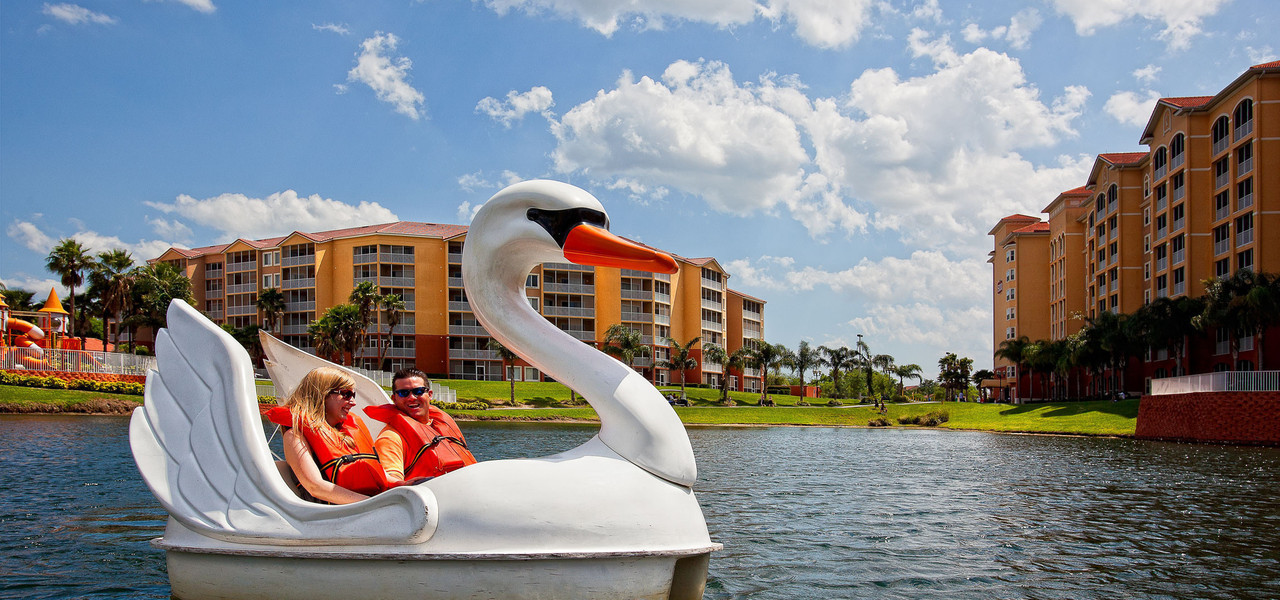 couple enjoying swan boat at resort near disney world - westgate town center resort