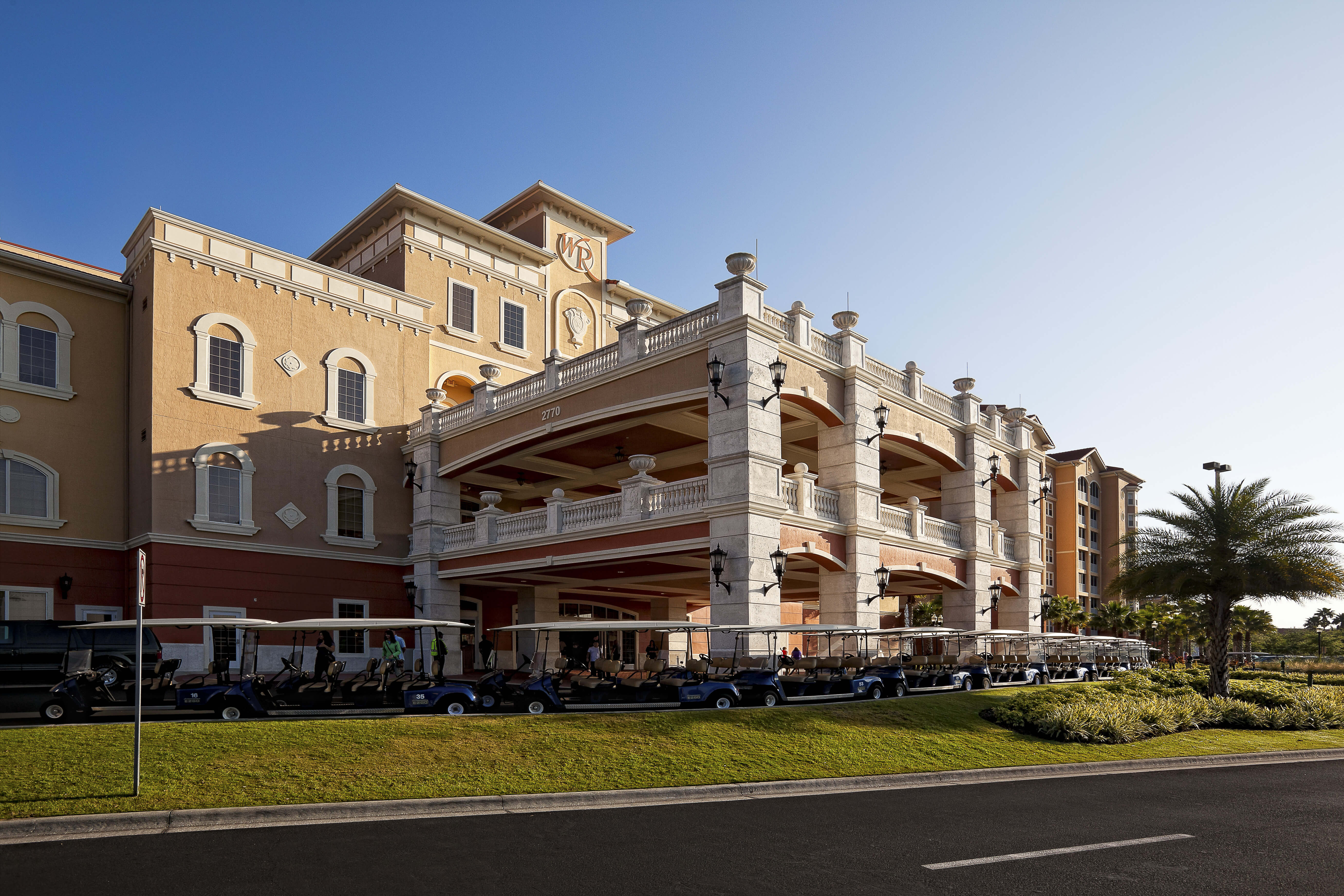 Entrada principal del complejo con carritos de golf estacionados | Westgate Town Center Resort & Spa