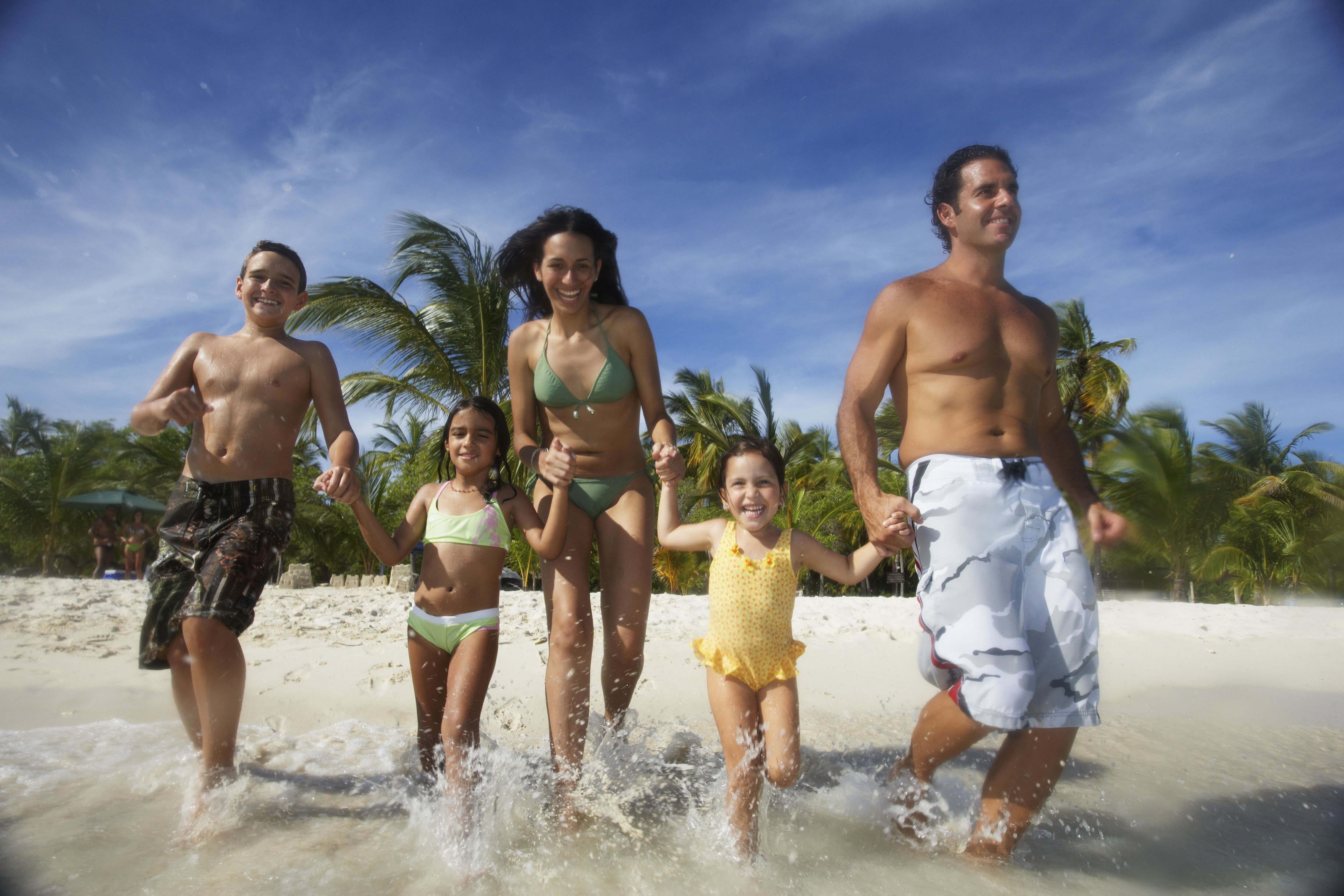 Happy Family Frolicking on a Beach | Westgate Resorts