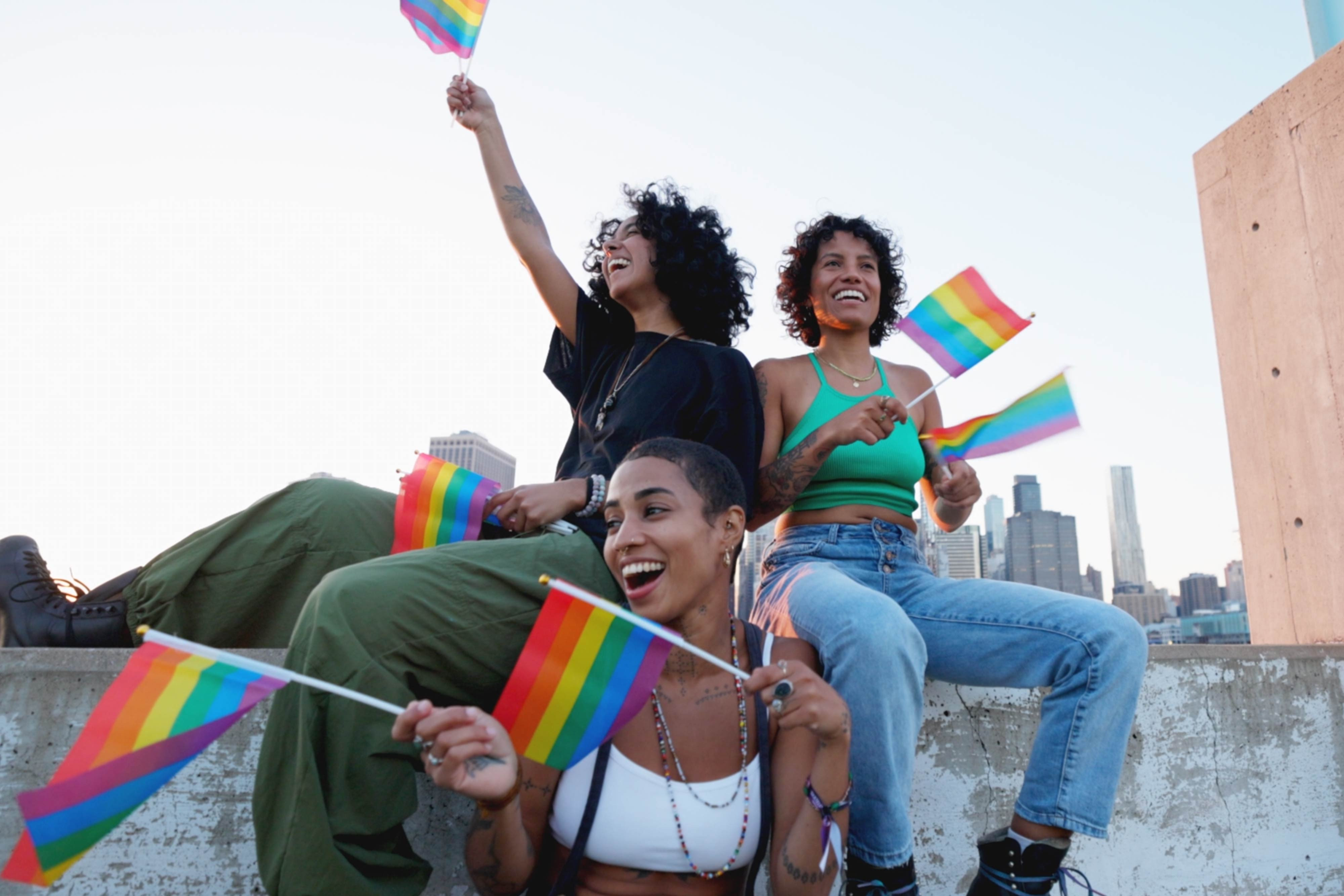 Desfile del Orgullo Gay en Nueva York - Westgate New York Grand Central - Mujeres ondeando banderas del orgullo en la azotea