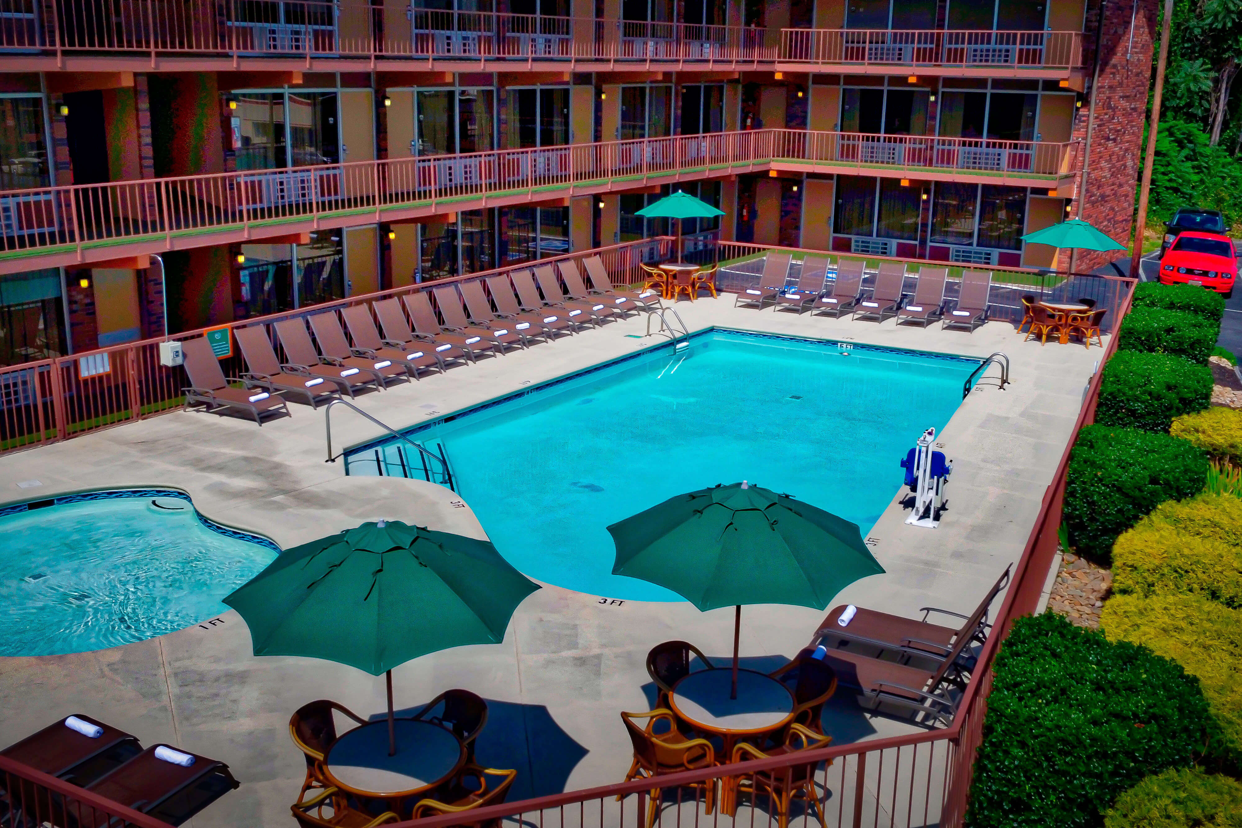 Outdoor pool and children's wading pool surrounded by lounge chairs | Wild Bear Inn | Westgate Pigeon Forge Resorts
