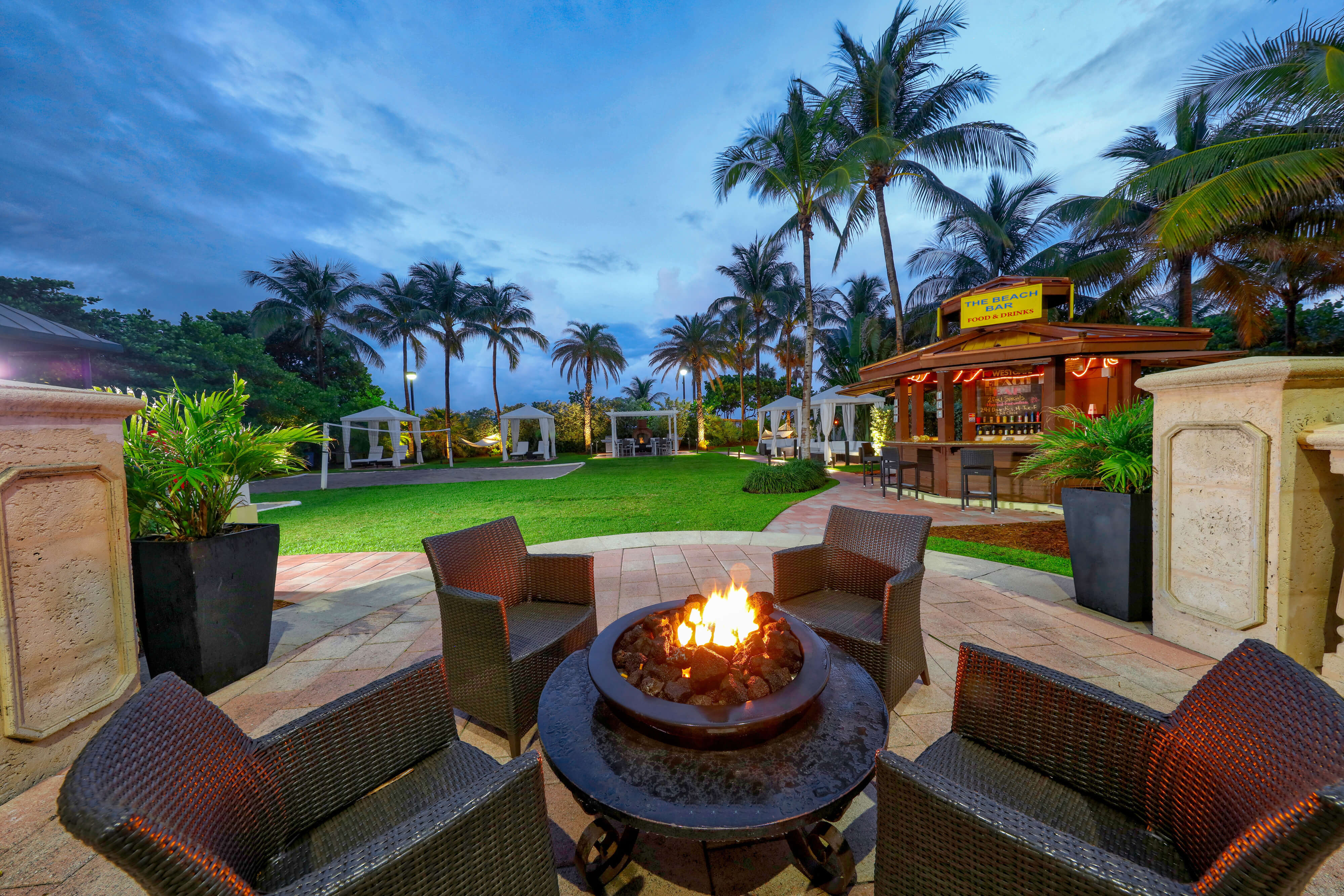 Outdoor deck with fire pit and chairs in front of The Beach Bar | Westgate South Beach Oceanfront Resort